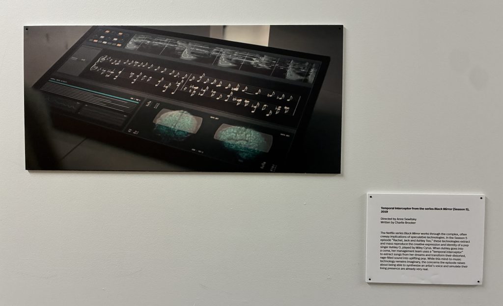 A digital display featuring futuristic technology, showcasing waveform graphs and visualizations of brain activity, representing concepts from the series 'Black Mirror.'